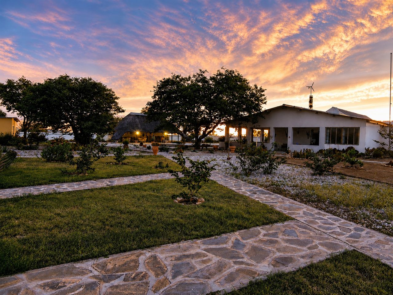 Wildlife Lodge SATURN im rosa Abendlicht — Hauptgebäude, Lapa und Garten im weiten Damaraland