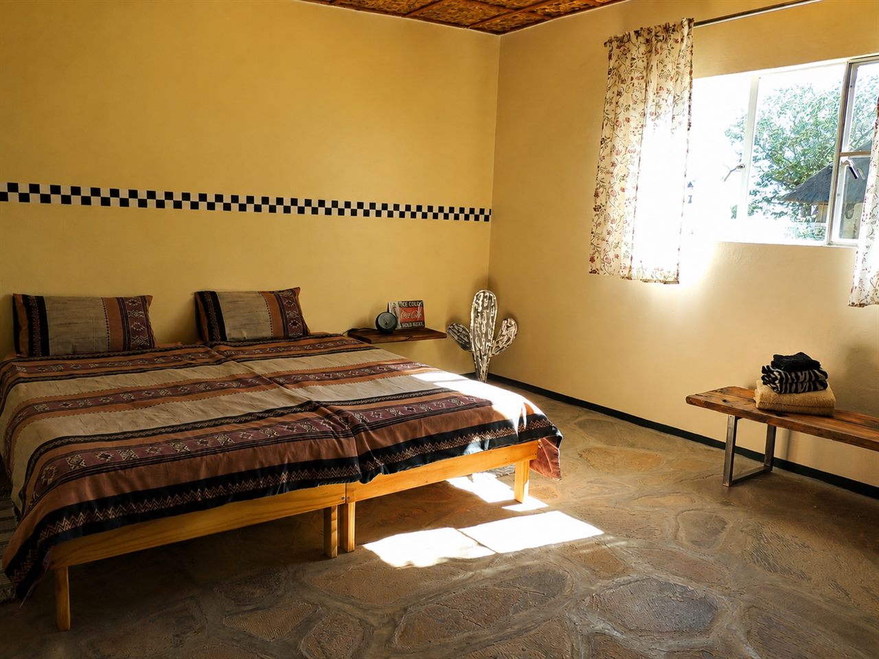 Helles, einladendes Schlafzimmer im Gästebungalow mit Bett und Sitzbank